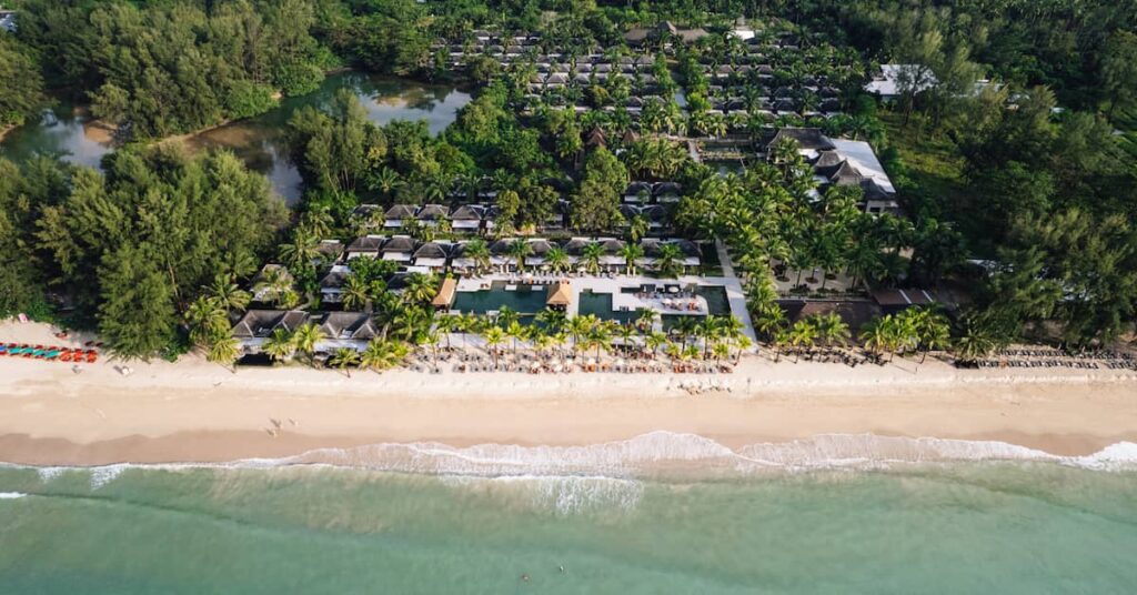 Aerial view of a luxury Khao Lak beach resort showing beachfront villas, swimming pools and direct beach access along the Andaman coast.